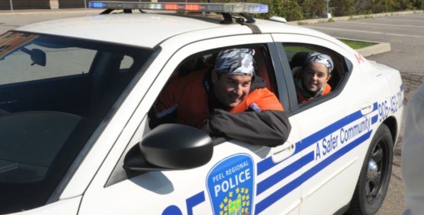 Hala Events - The Amazing Raise cruising in a police car